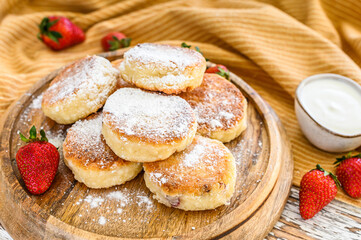 Obraz na płótnie Canvas Cottage cheese pancakes, syrniki, curd fritters with strawberry. Gourmet Breakfast. White background. Top view