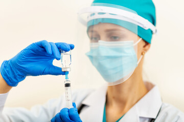 Doctor or nurse holding hands flu vaccine on beige background, measles injection syringe for baby, man, woman vaccination, medicine and drug concept. Vaccination against Coronavirus covid-19 pandemic