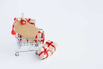 Blank card on shopping cart with gifts on white background with copy space. - 393507502