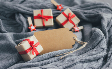 Christmas gift boxes, New Year decorations and blank card on cozy gray sweater. - 393507535