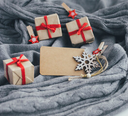 Christmas gift boxes, New Year decorations and blank card on cozy gray sweater. - 393507547