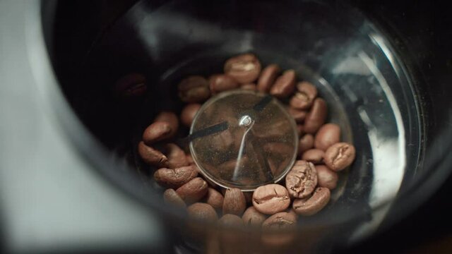 4K SLOW MOTION | Grinding fresh coffee beans in a electric grinder with burrs crushing the beans