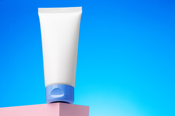 Blank white cosmetic container against blue background