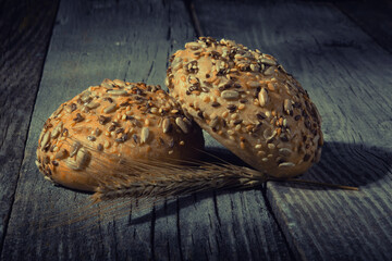 Gluten free whole grain buns on wooden table on dark background