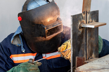 Welder qualification. The welder is welding with shielded metal arc welding process to steel plate in vertical position for welder certification.