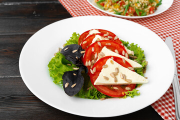 Fototapeta na wymiar Salad with fresh tomatoes and brined cheese, sunflower seeds on top