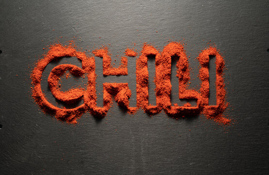 TOP VIEW: Word "Chili" from dry chili powder on black background