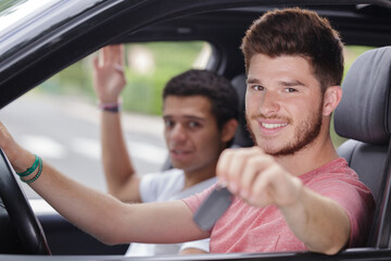 two happy young men sitting in the car