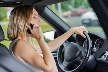 Fototapeta na wymiar woman talking on cell phone while driving her car