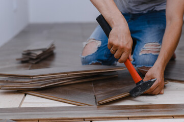 Man laying parquet flooring - closeup on male hands. worker joining parquet floor