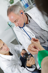 trainee doctor reading blood pressure gauge