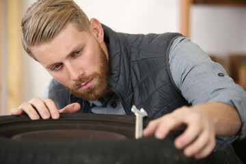 Obraz premium close up of mechanic checking a black tire