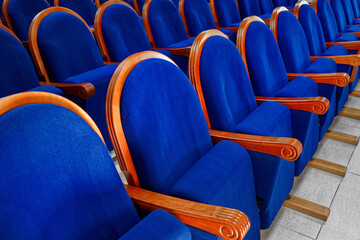Obraz premium Blue velour chairs with armrests in the Assembly hall. Expensive and noble furniture in a row close-up.
