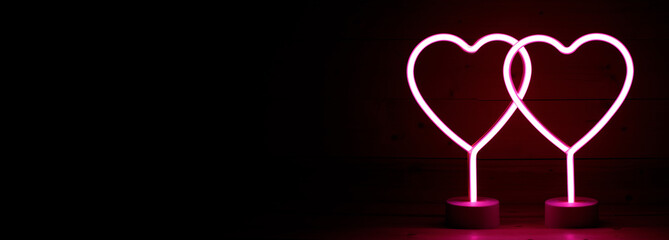 Two glowing pink neon hearts