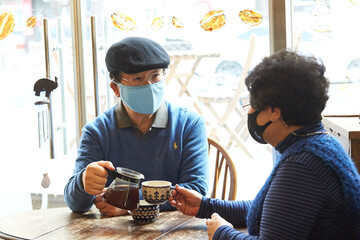 커피를 마시며 여유로운 시간을 보내는 노부부