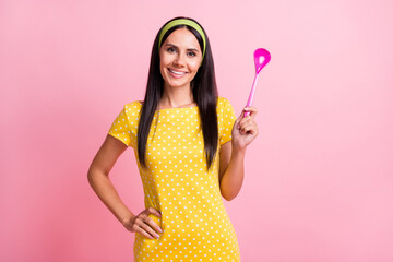 Photo of positive young housewife hold spoon hand waist nice smile isolated on pastel pink color background