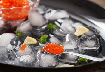 red carviar with ice on black plate