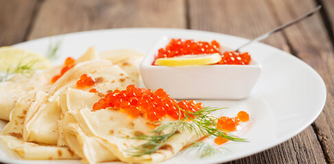 red caviar with pancakes on white plate