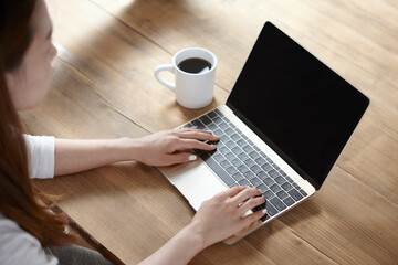 커피를 마시며 노트북으로 일하는 여성