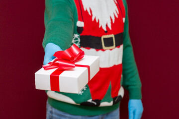 Close up cropped shot of male hands holding white gift box on red background.studio shot.