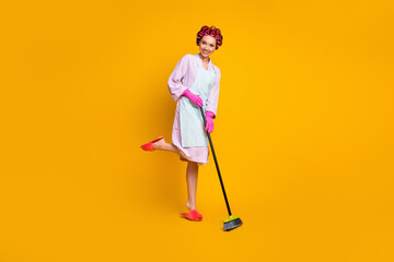 Full length body size view of attractive cheerful maid jumping sweeping duty home comfort isolated bright yellow color background