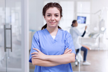 Portrait of stomatology nurse in dental reception with arms crossed looking at camera wearing...