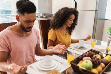 Latin American family having breakfast at home. family praying before eating