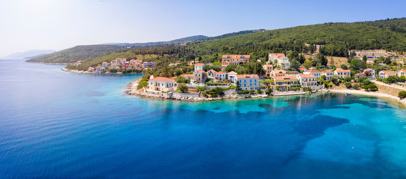 Panoramic aerial view to the beautiful village of Fiskardo on the island of Kefalonia, Greece, with colorful, red roofed houses by the turquoise sea