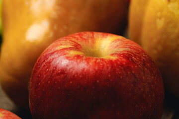 Red apple and two pumpkins on table close up
