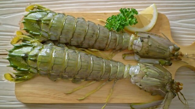 fresh mantis shrimp with lemon on wood board