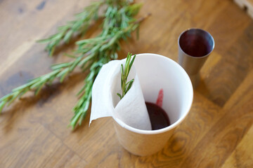 Black tea with jam and rosemary in a paper cup