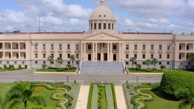 Forward aerial shot with drone of the Presidential Palace of the Dominican Republic, on a clear day, cloudy blue sky
