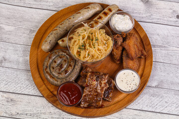 Fototapeta premium Meat plate with grilled sausages, ribs and chicken wings
