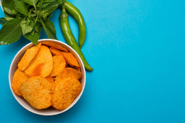 Potato chips with paprika on blue background