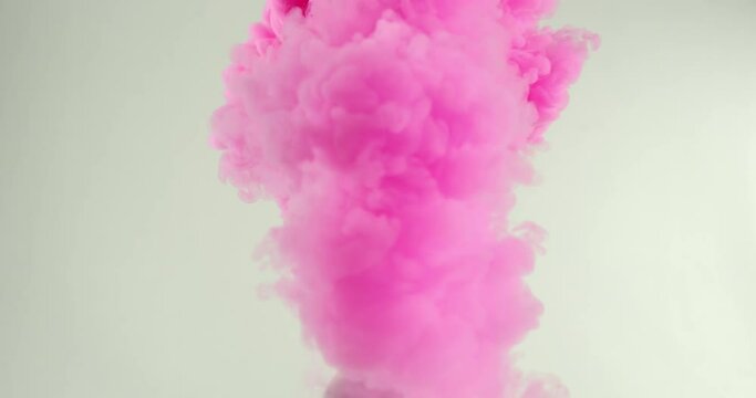 The balloon explodes, releasing thick bright pink smoke.