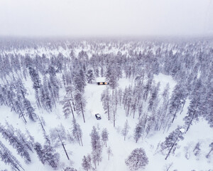 Visit Lapland Holidays. Aerial drone panorama shot of the forest covered in snow winter and the village inside the Arctic Circle. Lapland, Finland. Winter sunrise. Igloos and cabins covered with snow