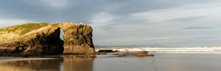 panorama of a sunrise at the Playa de las Catedrales Beach in Galicia in northern Spain