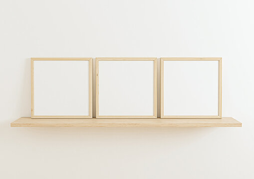 Triple 8x8 Square Wooden Frame mockup on wooden shelf and white wall. Three empty poster frame mockup on wooden shelf and white background. 3D Rendering