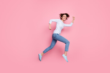 Fototapeta na wymiar Full length photo of cheerful girl enjoy winter season sales jump run fast isolated over pink color background