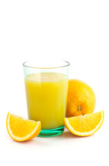 Glass of fresh orange juice with sliced oranges on white background.
