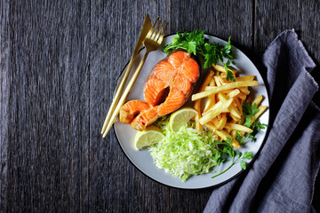 salmon steaks with potato fries and coleslaw