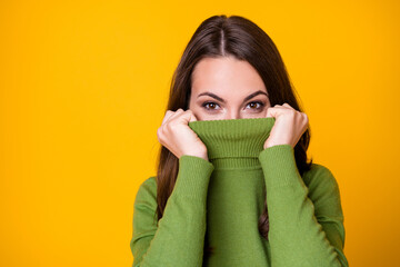 Close-up portrait of pretty funny girl hiding face in warm sweater autumn isolated over bright yellow color background - Powered by Adobe