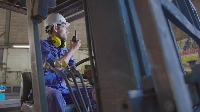 Concentrated forklift caucasian driver operating machine and holding hand on steering wheel radio comminication operate teamwork with Stressed frustrated upset about problem