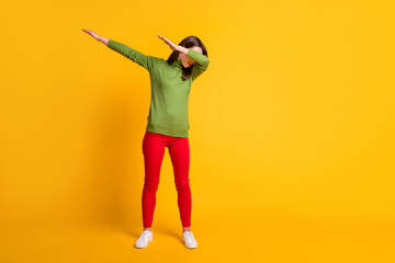 Full length body size view of attractive skinny funky girl dancing showing dab move clubbing isolated bright yellow color background