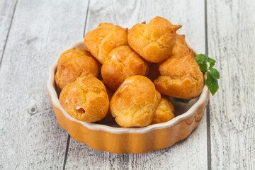 Sweet tasty profiteroles heap in the bowl