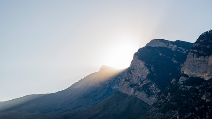 landscape bright rays of the sun break through the top of the mountain