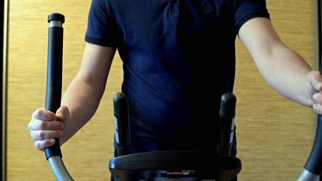A man exercising on elliptical trainer machine
