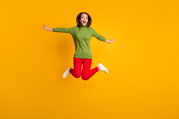 Fototapeta na wymiar Full body photo of lady jump up air flight rejoicing wear casual pullover sneakers red trousers isolated yellow color background
