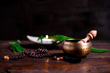 Close-up of a singing bowl and prayer beads (mala) for chanting mantras as a decoration on an old wooden board