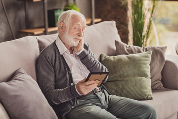 Photo of cute pensioner wear grey cardigan sitting couch looking photo frame good memories arm cheek indoors house flat